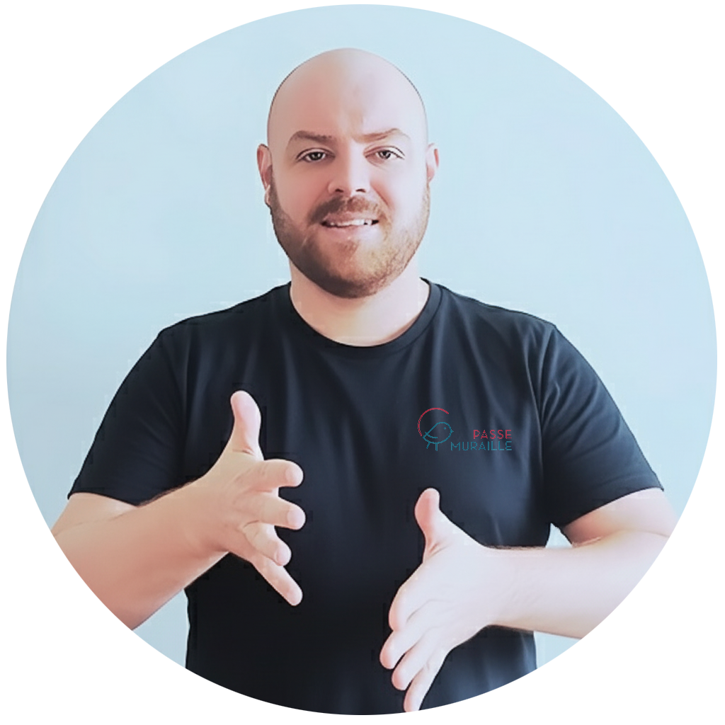 Benjamin votre formateur en langue des signes qui sourit face objectif et il signe la langue des signes