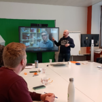 Image de notre formateur en langue des signes donne court dans une salle avec une télévision en support visuel pour ses explications